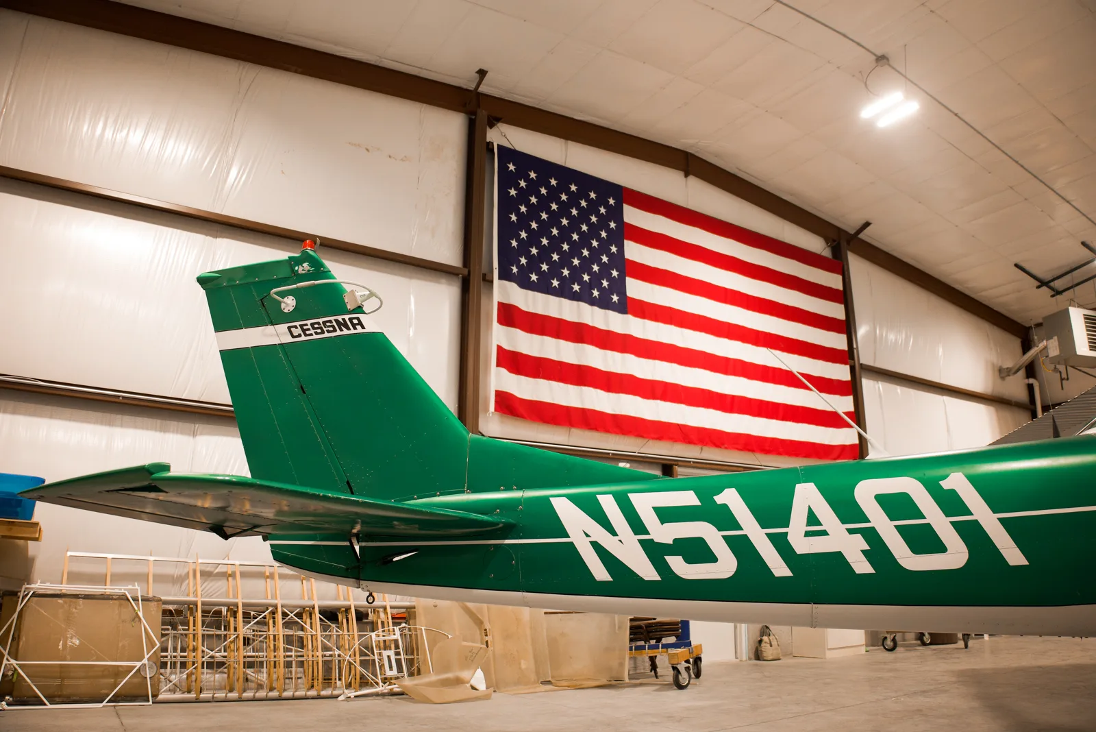 Vintage green Cessna in profile with the American flag behind