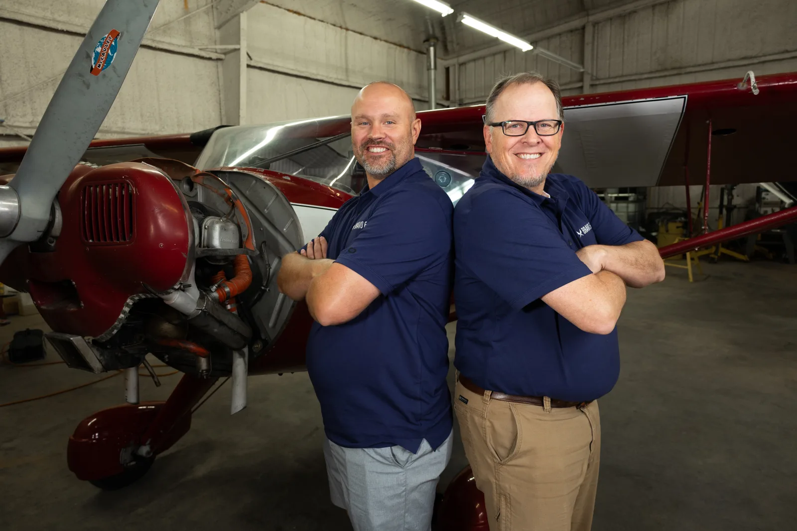 Two Bravo 6 instructors by a red aircraft
