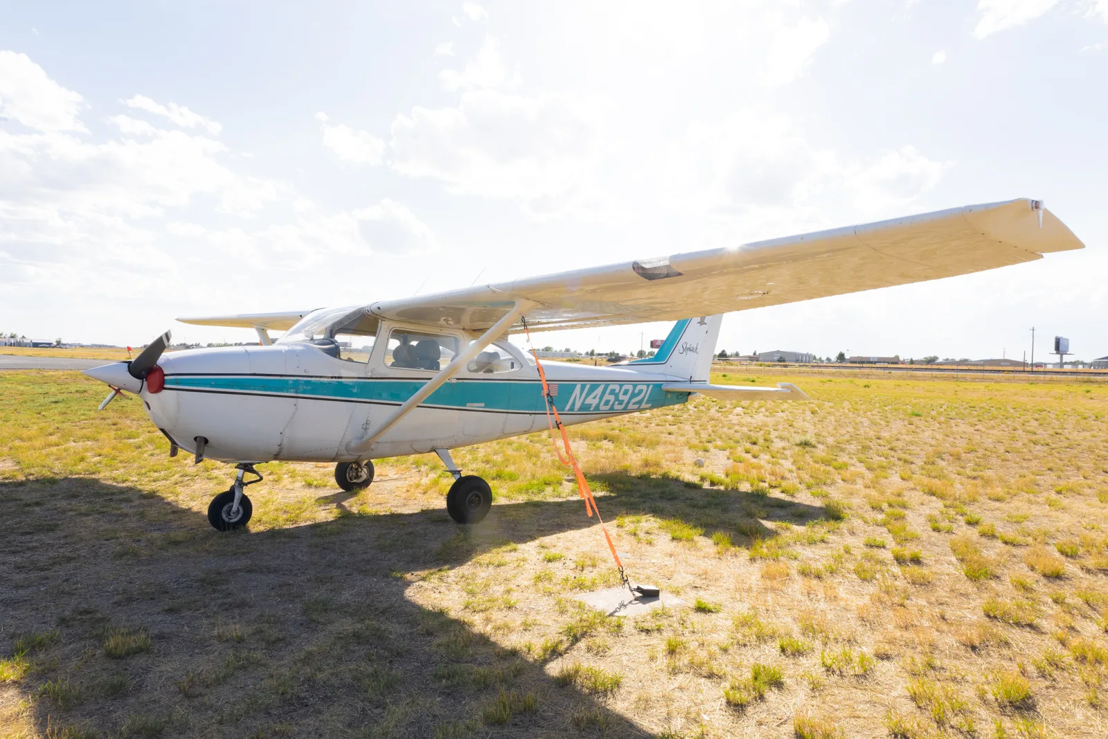 Vintage teal Cessna on a grass field