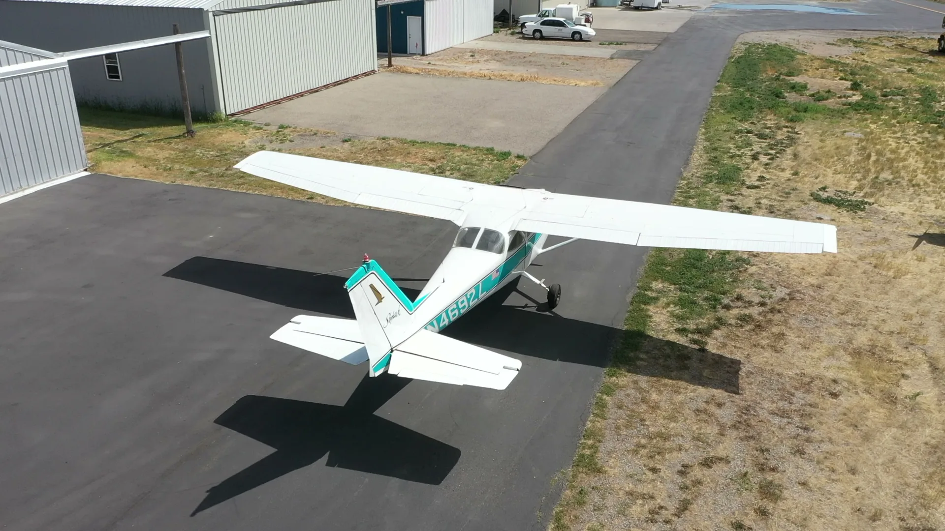 Aerial of a Cessna Skyhawk casting a long shadow across the ramp